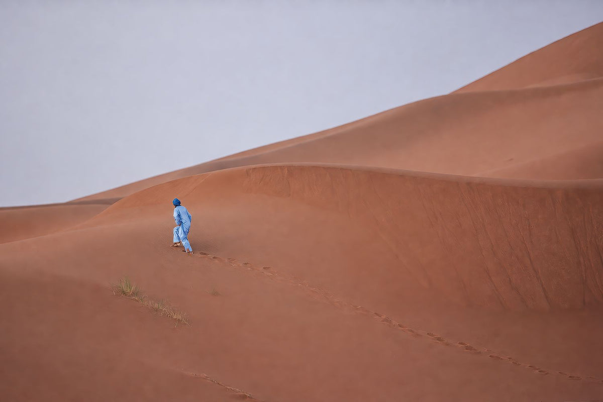 Blue Figure Across Quiet Dunes